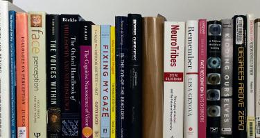 Rectangular photo of Sadie Dingfelder’s office bookshelf with titles on memory, face perception, cognitive neuroscience, and self-discovery. Photo credit Sadie Dingfelder