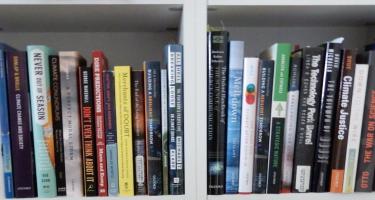 Rectangular photo of Dennis Meredith’s office bookshelf showing books on climate change, doubt, denial, and the war on science. Photo credit: Dennis Meredith.