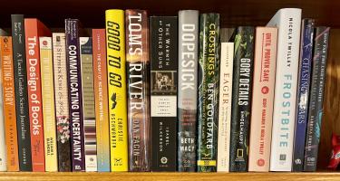 Rectangular photo of Siri Carpenter’s book shelf with titles on writing, science writing, book design, and science communication. Shelf also includes several works by NASW authors. Photo credit: Siri Carpenter.