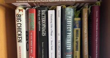 Rectangular photo of Lina Zeldovich’s office bookshelf with titles on bacteriophages, superbugs, and molecular biology. Photo credit: Lina Zeldovich.