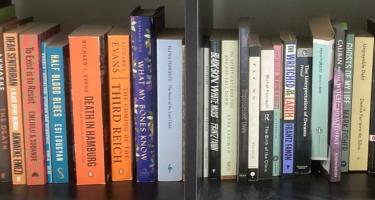 Rectangular photo of Edna Bonhomme’s office bookshelf showing works on illness, medical care, stigma, race, feminism, Nazi Germany, and more. These two shelves are a selection from a wall of books on the history of science. Photo credit: Edna Bonhomme.