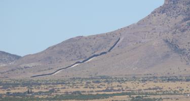 Rectangular photo showing one of the last sections of the border wall nearing completion at the time of the author’s visit in May 2022. 