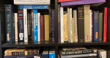 Rectangular photo of Kenneth Miller’s office bookshelf showing titles on sleep, sleep disorders, chronobiology, and dreams. Photo credit Kenneth Miller.