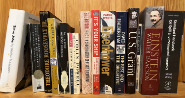 Rectangular photo of Christopher Reddy’s office bookshelf showing books on leadership and leaders, including U.S. Grant, Theodore Roosevelt, Albert Einstein, Dwight Eisenhower, and Steve Jobs. Photo credit: Christopher Reddy 