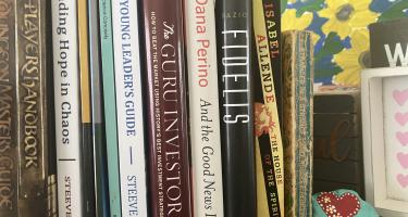 Rectangular photo of Sheeva Azma’s office bookshelf showing books on science communication as well as literature and other topics in which she finds inspiration. Photo credit Sheeva Azma.