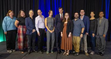 Photo of N A S W journalism and institutional writing award winners posing with N A SW board and committee leaders on stage