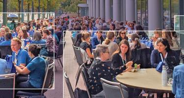 Clipped shot of the 2023 Winter Spring Science Writers magazine cover, showing conference attendees eating in large tables outdoors, highlighted by stylized frames and squares.