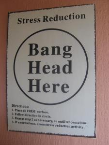 Sign on wall: "Bang head here"