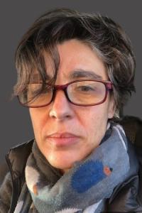 Portrait photo of Alla Katsnelson in glasses and scarf.