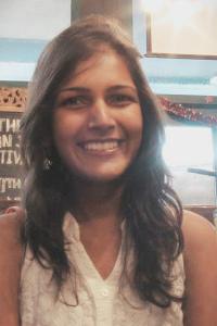 Portrait photo of Priyanka Runwal smiling inside a bookstore