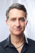 Portrait photo of Vince Beiser wearing a collared shirt in a studio setting. Photo credit Spencer Lowell.