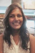 Portrait photo of Priyanka Runwal smiling inside a bookstore