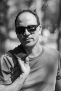 Portrait photo of Christopher Pollon wearing sunglasses and a t-shirt and with one hand slinging a jacket over shoulder. Photo credit Fernando Lessa.